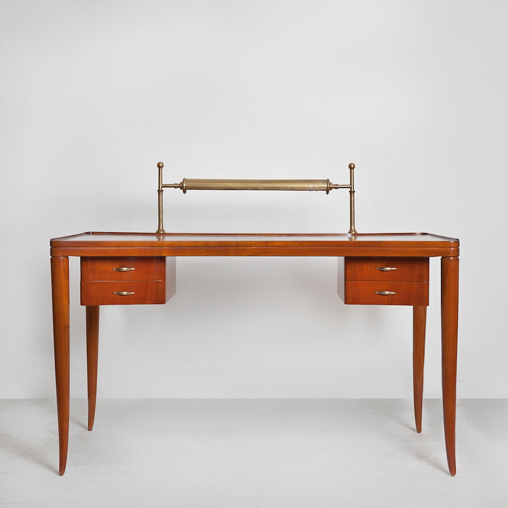 Rare and important illuminated desk by Guglielmo Ulrich, in carved cherrywood, with gilt aluminum (Xantal) handles and supports, carved tapered legs and two floating banks of drawers. Produced by Jannace & Kovacs (cabinetmaker's) in 1947. Signed,