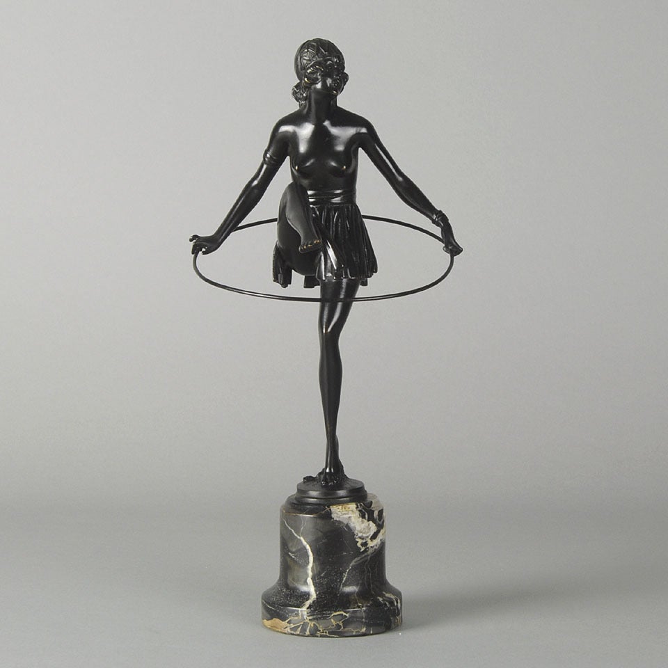 A very fine dark patinated bronze figure of an Art Deco costumed dancer with a hoop, raised on portoro marble conical plinth and signed B Zach.

References:
Art Deco and other figures by Bryan Catley.
Art Deco sculpture by Victor