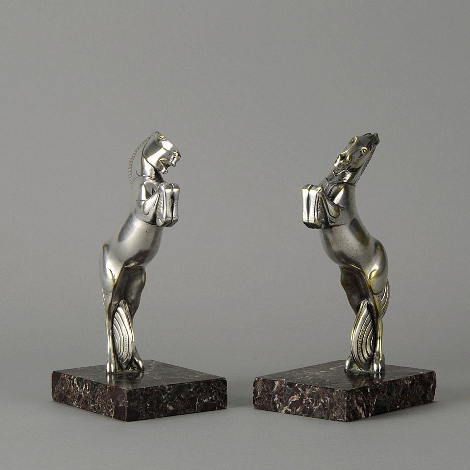 A dramatic pair of silvered bronze bookends modelled as stylized rearing horses and raised on variegated marble rectangular plinths, signed Becquerel and impressed with foundry mark Etling Paris..

References
Art Deco and other figures by Bryan