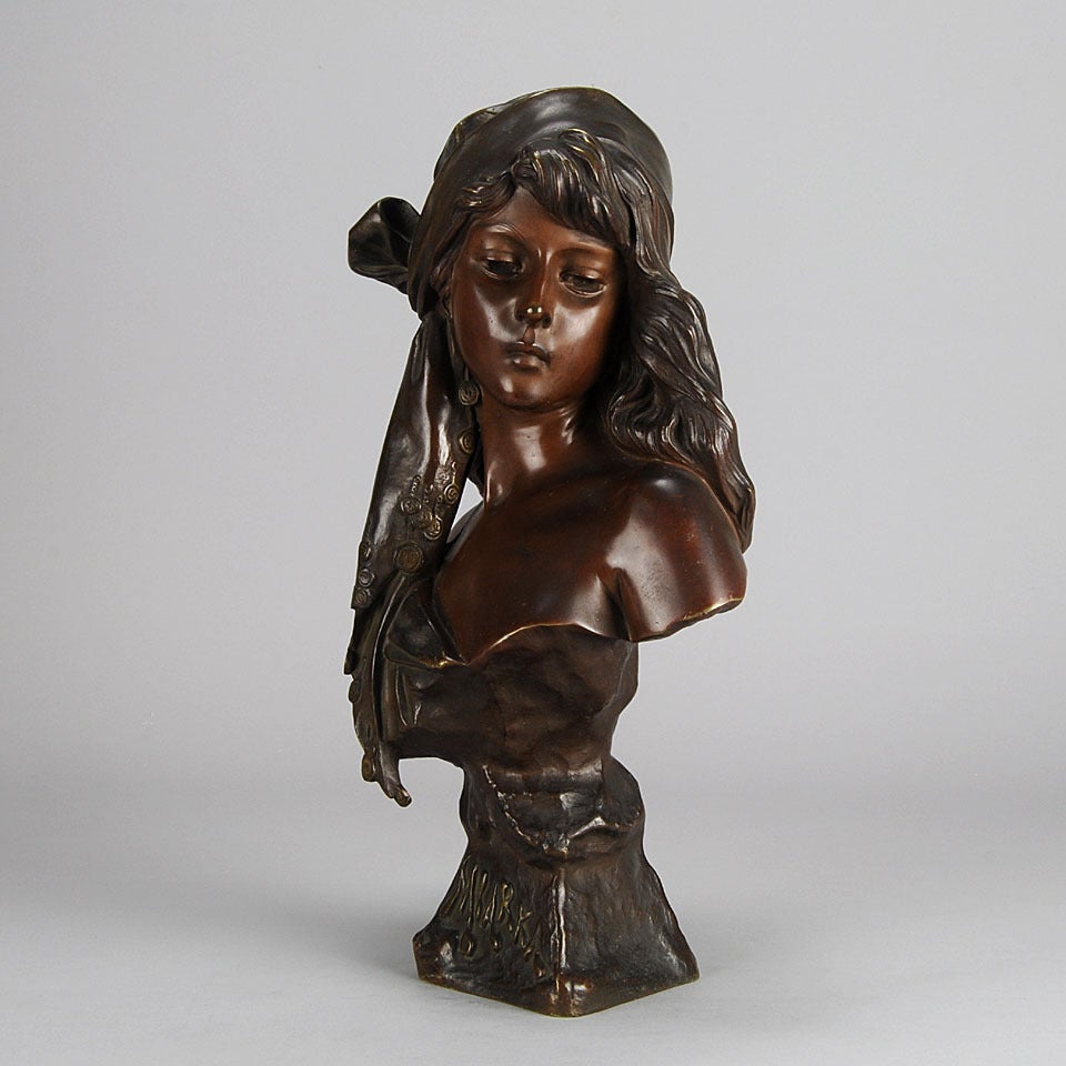 A beautiful late 19th Century Art Nouveau bronze bust of a captivating young gypsy woman wearing a loose head dress with long flowing locks of hair, enhanced by the rich multi-toned patination and excellent tactile surface of her skin. Titled to the