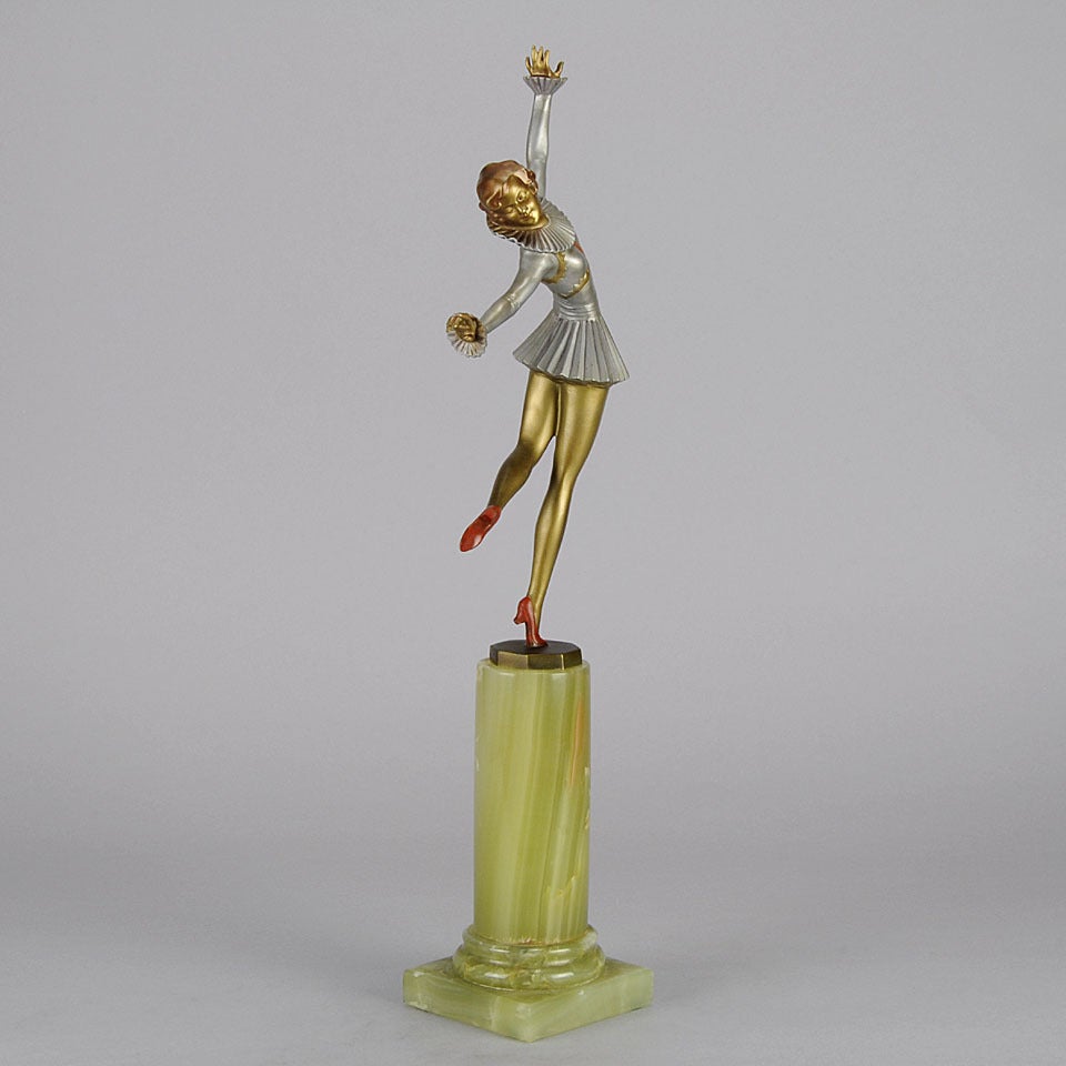 An eye catching and elegant Art Deco Austrian bronze figure of a young flapper wearing period costume in a striking stylised pose. The bronze exhibits very fine cold painted colour and good hand finished detail. Signed Lorenzl and stamped with the
