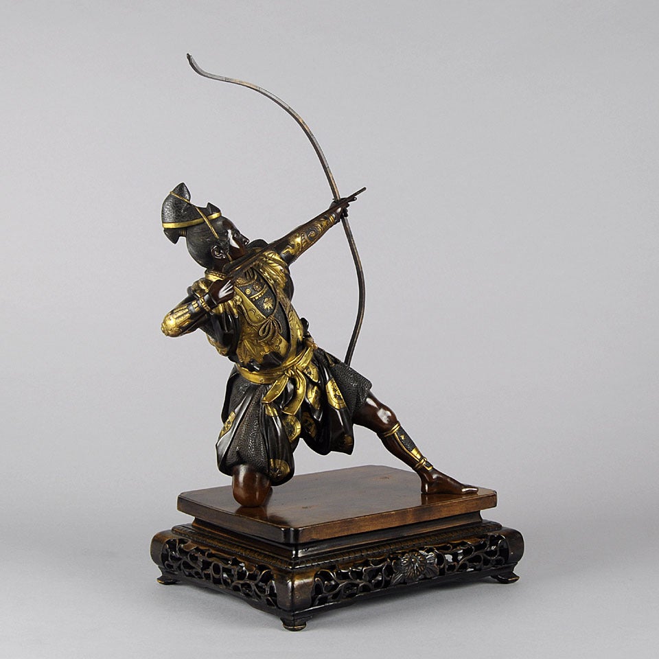 An impressive parcel gilt bronze okimono of superior quality modelled as a kneeling Samurai Archer with his bow fully drawn raised on a shaped wooden stand, signed on recessed plaque

S Yoshimitsu

Japanese Late 19th C

An important Tokyo