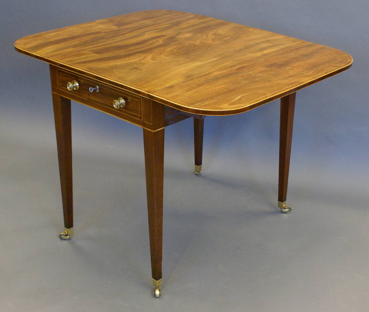 In finely grained Cuban mahogany and detailed with box-wood stringing. The table retains all its original brass work and is of very good faded colour and condition and has been recently lightly and sympathetically restored.