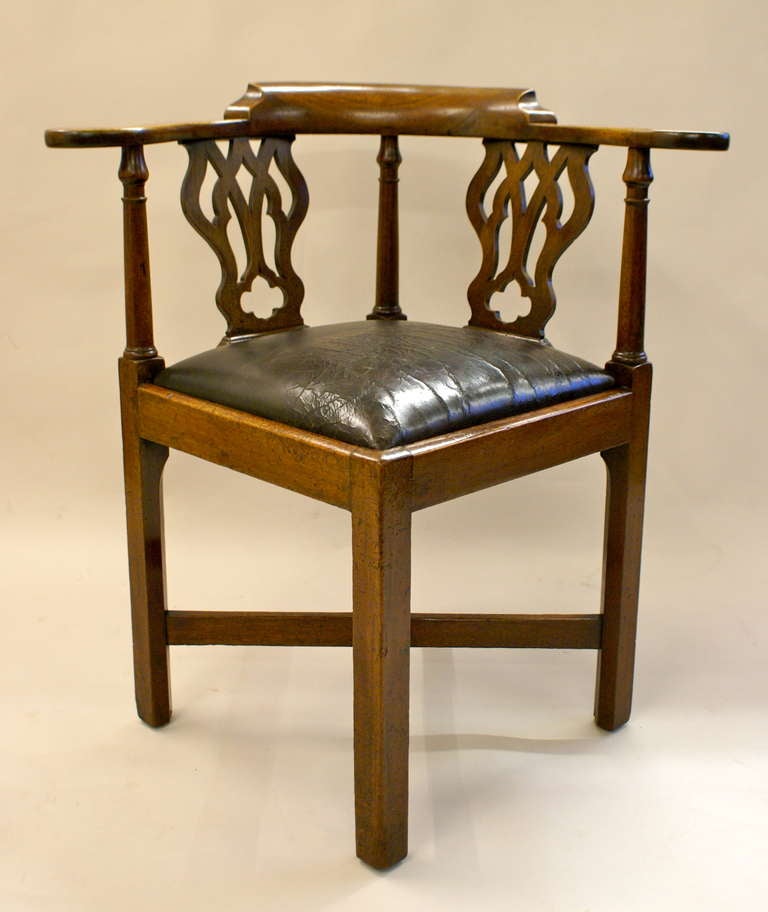 On square chamfered legs with cross stretcher, the back  3 turned supports and 2 pierced back splats all supporting the curved arm rail. The seat has been re-upholstered reusing the leather which is probably 19th century.  In very good original