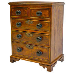 An early 19th century Fruitwood miniature chest of drawers