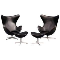 Pair of Black Leather Egg Chairs and Foot Stools