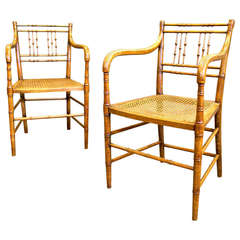 A pair of Regency faux bamboo arm chairs
