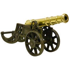 A Victorian brass ornamental cannon on cast iron carriage.