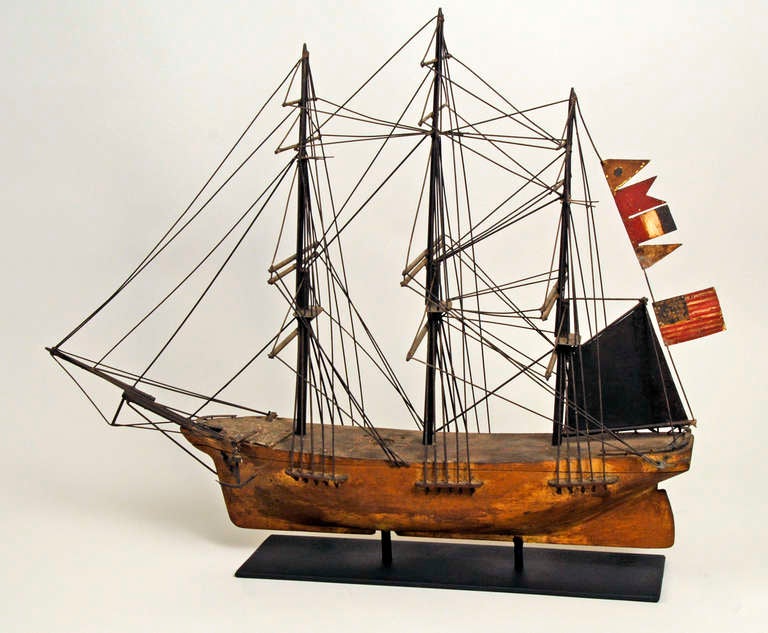Interesting folk art clipper ship weathervane. Carved wood hull with gold leaf. Rigging and flags are painted metal. New England, circa 1920. Original condition.