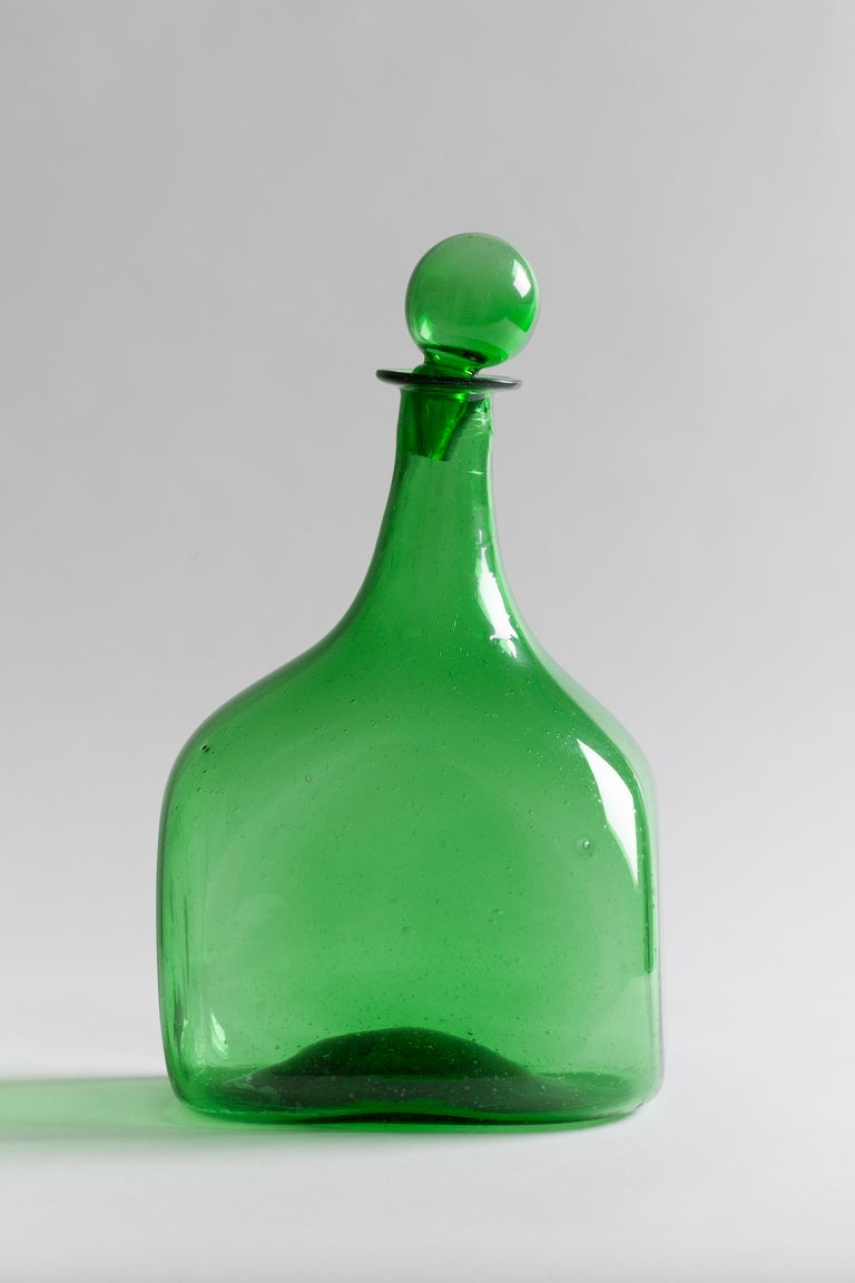 Bottle-green slant-necked decanter.