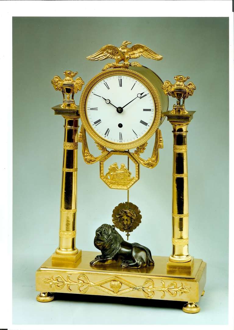 A decorative Regency period, early 19th century bronze and ormolu mantel clock by Baetens of Soho in London. The Fine quality fusee movement of week duration, has a white enamel dial in a drumhead case. The dial is surmounted with a finely cast