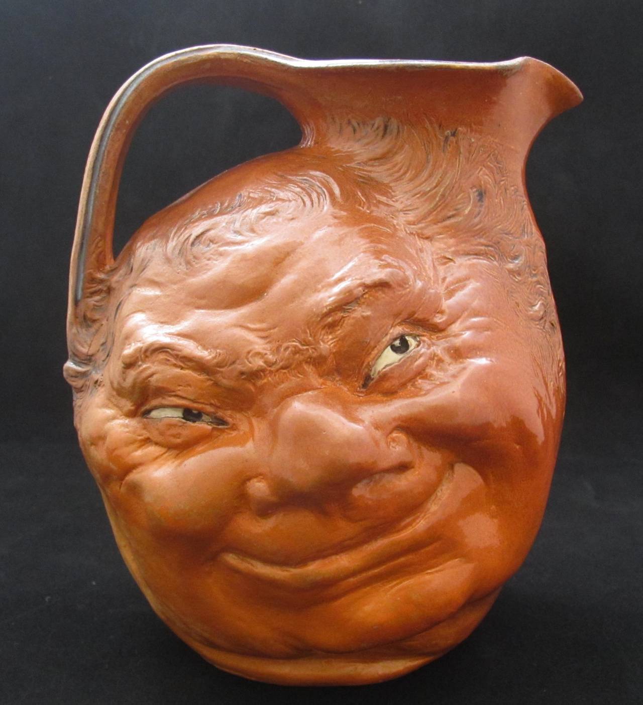 Large Martin Brothers Face Jug. This well modelled example has typical glaze irregularities and firing cracks and is dated 1899