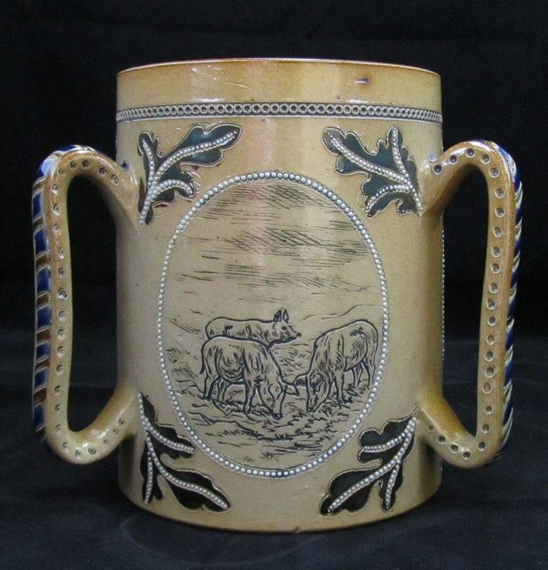 Doulton Lambeth 3 handled Tyg decorated with Pigs by Hannah Barlow (restoration to rim chip).