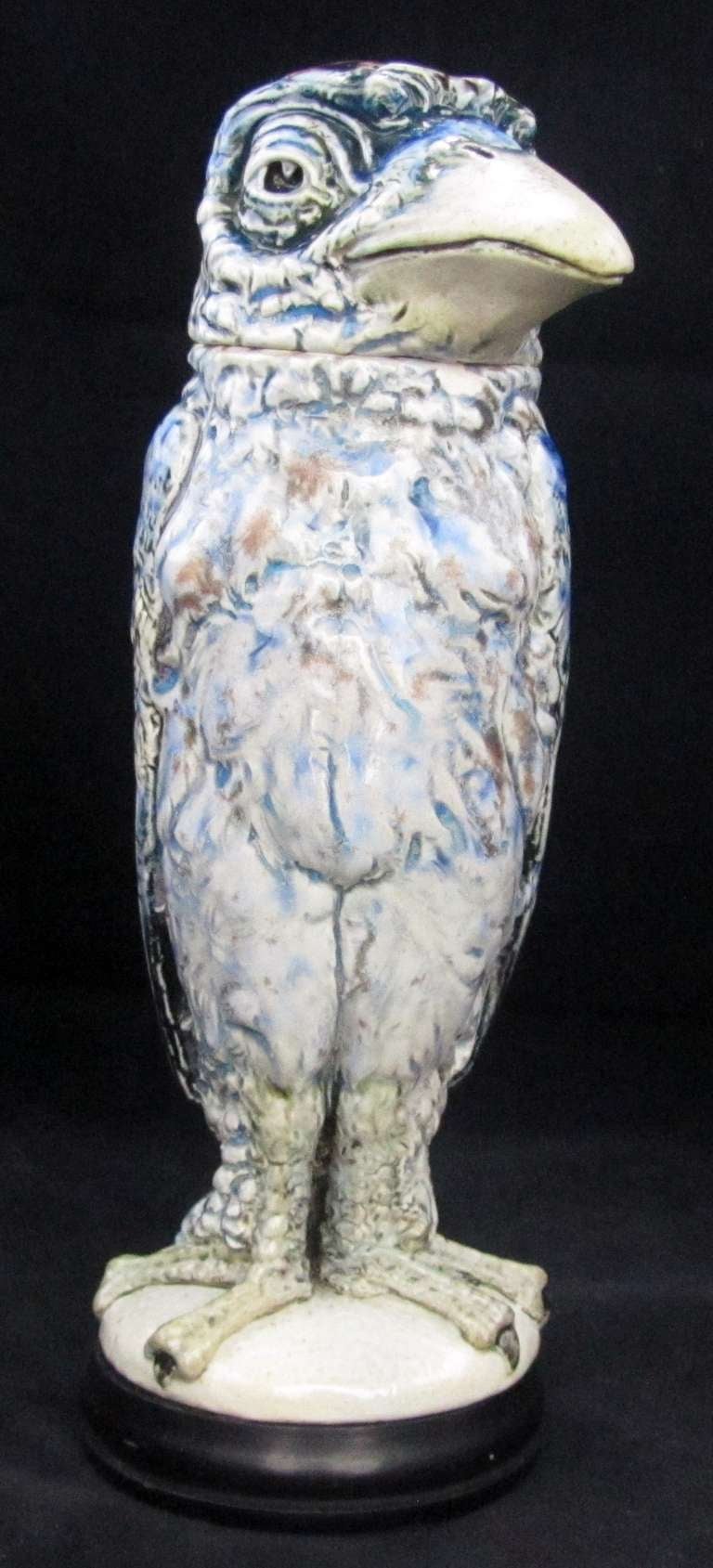 Martin Brothers tabacco jar modeled as a grotesque bird with a blue and aubergine glaze.There is a chip to the collar of the body which is partially obscured by the large beak when the head is in situ.