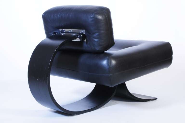 1972 easy chair and foot-rest by Oscar Niemeyer, edited by Tendo, Base in lacquered black plywood, chair-seat, back and foot-rest in black leather, steel fastening system. 

Dimensions of the foot-rest :  height  43 cm., length 71 cm., depth 71 cm.