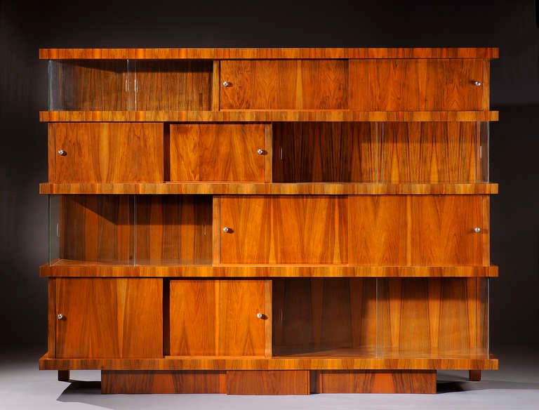 Exceptional modernist bookcase by Jacques Adnet in varnished walnut veneer, with projecting shelves; sliding doors with round chrome metal pulls. Glass doors. Circa 1933.
Bibliography: Alain-René Hardy 