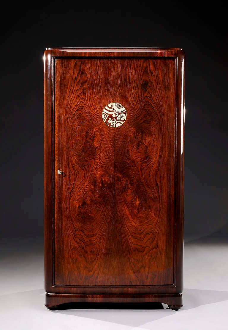 Rare armoire by Jules Leleu, in rosewood veneer, with a geometric decoration of bone on the door. Eight interior drawers, with two with keys. Circa 1925.

