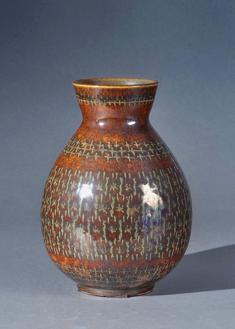 Vase en céramique des années 1940 de Pierre Fouquet, signé sous la base, à panse renflée et col étroit, décoré de rayures sur fond marron.

