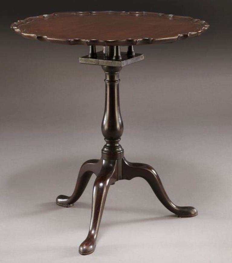 George II mahogany piecrust tilt-top tea table. Circular dished top on a revolving birdcage and baluster support standing on three cabriole legs.