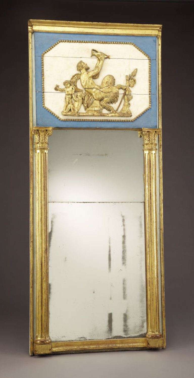 Continental giltwood and painted trumeau mirror. Stepped pediment over beaded gilt frame, encloses relief carved giltwood scene of bacchi and putti. Trumeau supported with pair of engaged giltwood columns w/Corinthian capitols.