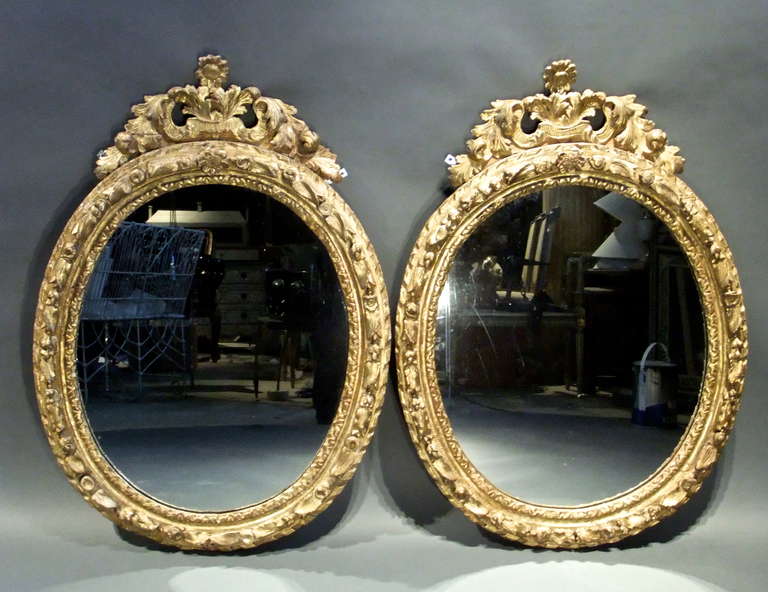 Pair of Louis XIV carved giltwood mirrors with a sun flower crest
