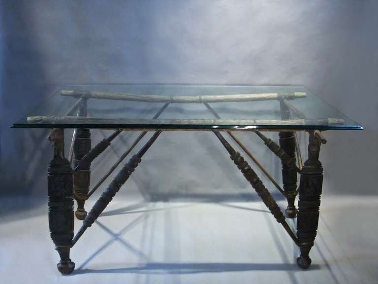 A Tuareg leather and wood saddle stand with glass top.<br />
