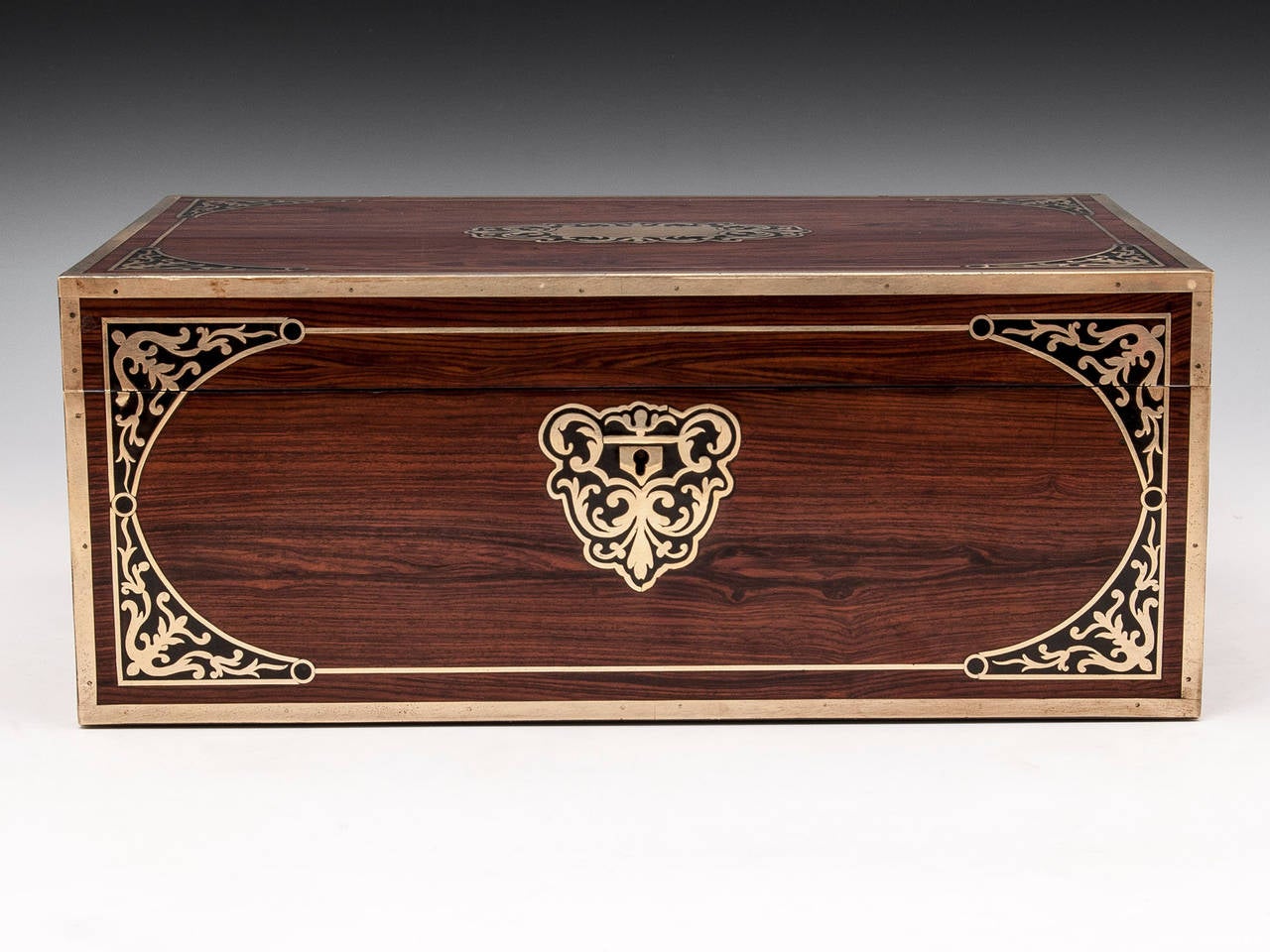Striking Kingwood writing box by David Edwards with decorative brass inlays, ornate escutcheons, brass carrying handles, gilded candle sconces and a secret compartment containing two hidden drawers. 

The interior features a replacement dark olive