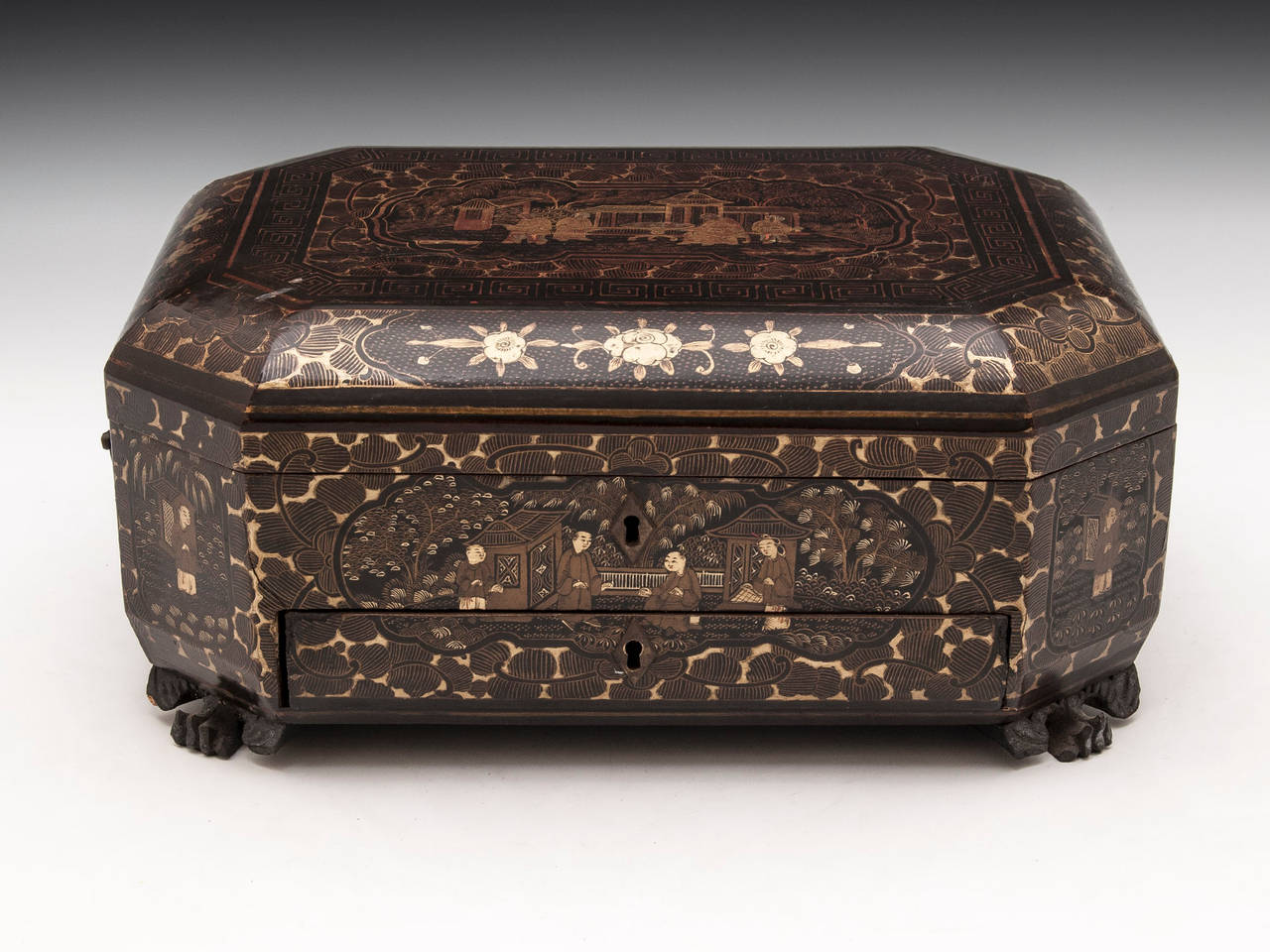 Chinese lacquer Sewing Box decorated with gold floral patterns and chinoiserie figures on the front and top all with exquisite detail, standing on four lion pad feet. 

The interior features a fully fitted tray with various compartments and lots