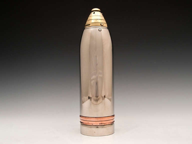 Cocktail shaker by American silversmith Gorham. The shaker has a copper ring near the bottom and a brass lid and cap. The base is stamped with 