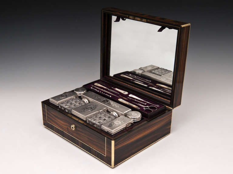 Edwards coromandel Silver Vanity box with brass edging and inlaid stringing.

The interior features eight glass containers each with beautifully engraved sterling silver lids and cut glass jars which are all housed in a removable tray with storage