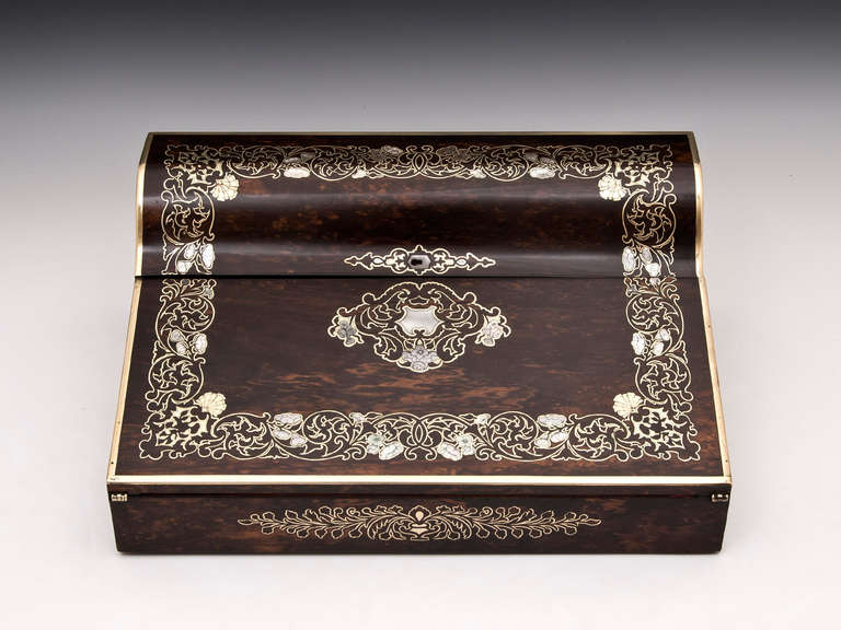 Unusually-shaped writing box typical of Turriil's superb workmanship, veneered in sumptuous coromandel and inlaid with an intricate combination of brass stringing and engraved mother of pearl flowers. The interior is veneered in birdseye maple, has