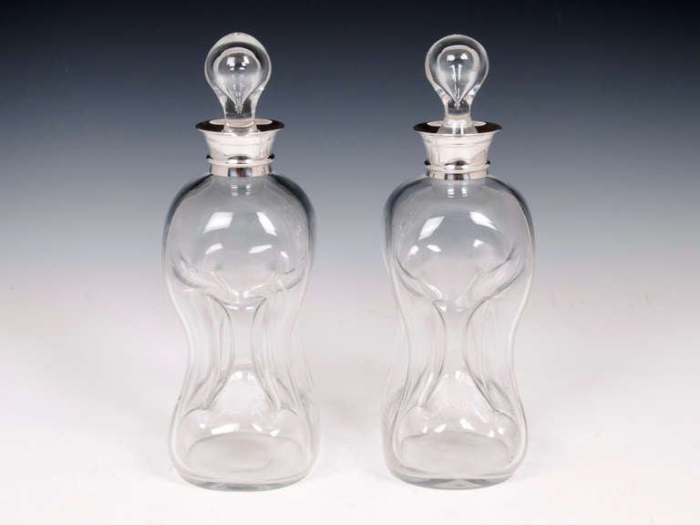 Pair of Glug Glug Decanters with ball stoppers by famous Birmingham Silversmiths Jonathan Wilson Hukin and John Thomas Heath. 

These fantatsic looking decanters get their name after the noise they make when pouring. 

Some images show three