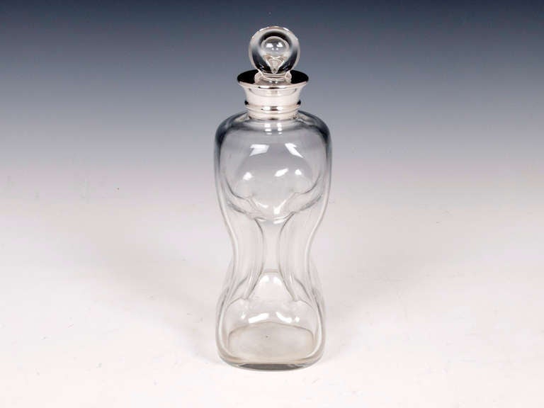 Glug Glug Decanter with ball stopper and sterling silver collar by renowned Birmingham Silversmiths Hukin & Heath. This type of decanter gets its name after the noise they make when pouring. 

Some images show three decanters these are not part of