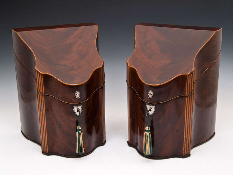 A stunning pair of unusual Georgian Mahogany serpentine knife boxes with serpentine sides, they have decorative fluted boxwood cants, sheild shaped silver plated escutcheons and small ring pulls and once lifted reveal the inlaid cutlery deck