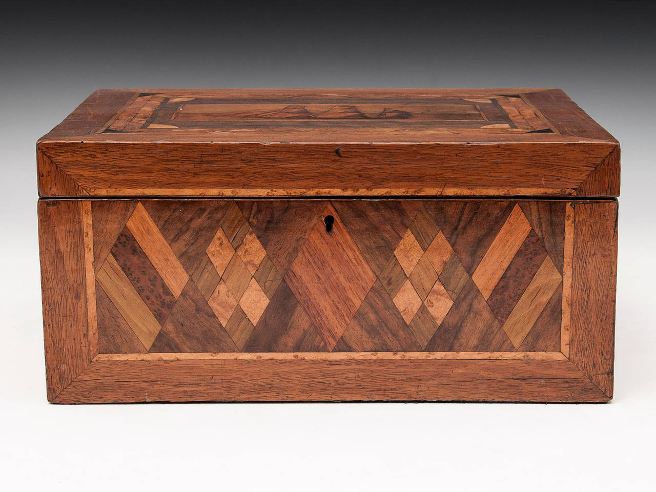 Trinity House Box veneered in mahogany and walnut with a view of a Tea Clipper on the top, diamond shape inlays on the front and Union jack inlays to each side. 

The interior is lined with blue paper and velvet. 

This sewing box comes with a fully