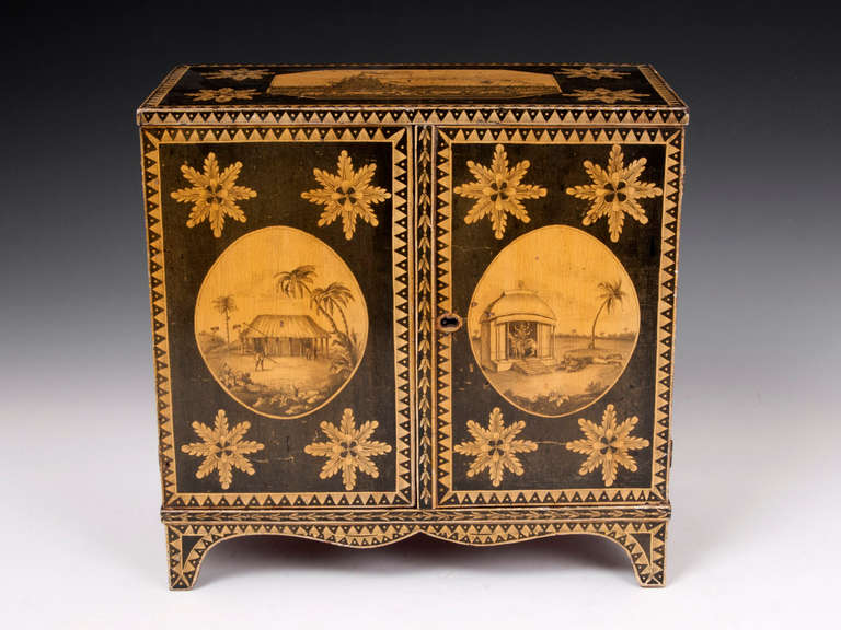 Intriguing and very rare Regency Penwork Cabinet. Decorated with various highly detailed scenes, the front of the cabinet open to reveal four drawers, each decorated with ancient characters and words. The scenes represent Indian culture - one of the