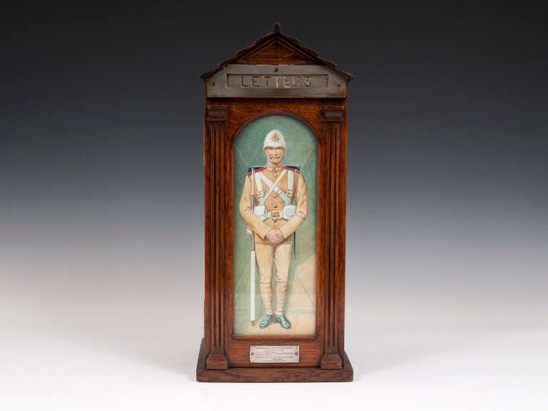 Country house oak letter box in the form of a sentry box.

Has a glazed door with a watercolor of a soldier from the Boer War, by famous military artist Richard Simkin.

The Inside of the door features the famous Army & Navy store plaque.

To