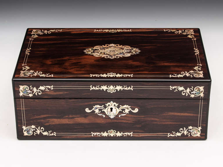 Antique Writing Slope veneered in coromandel with beautifully intricate engraved brass and Mother of Pearl inlays on the front and top of this eye catching box.

The interior is veneered in exotic Coromandel & Satinwood it features a black leather