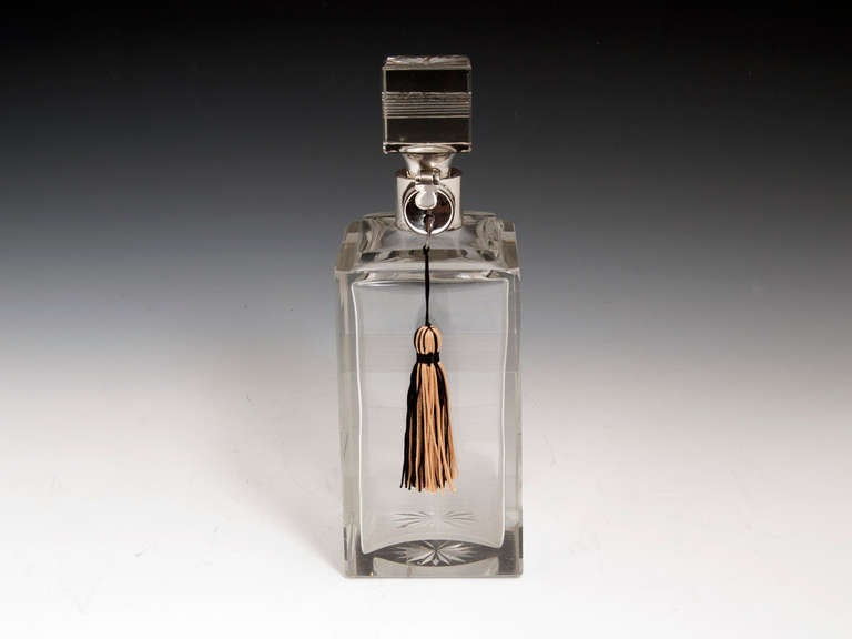 Art Deco lockable decanter by Hukin & Heath with simple cut glass lines on the body and stopper with the base and stopper both having star cuts. The silver collar is hallmarked Hukin & Heath, Birmingham 

The Art Deco Decanter comes with a fully