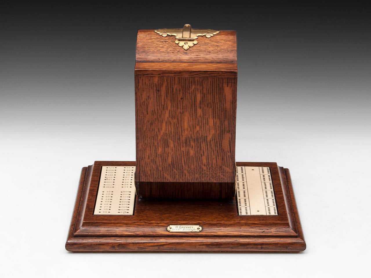 Unusual Cribbage Games box made of English Oak retailed by H. Greaves of New street, Birmingham. Has gilded brass mounts with two removable Ivory Crib marker boards. 

The interior opens by releasing the catch on the top, this reveals two