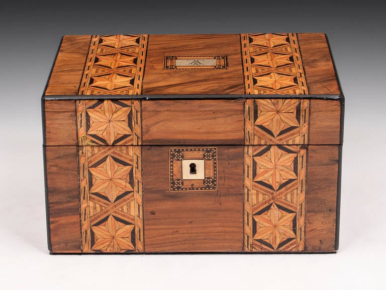 Jewelry Box with ebonized edging, two decorative bands with inlaid six point stars running from the front over the top and brass escutcheon and name plate. The interior features a blue velvet and leather paper lined tray with various compartments