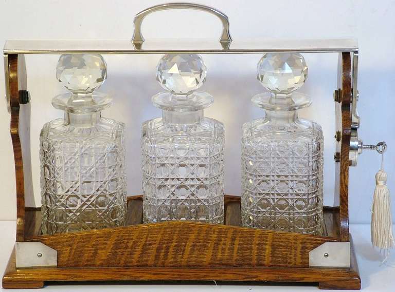 Art Deco 1920s Betjemanns Silver Plate Oak Tantalus with three full cut hobnail glass decanters, faceted stoppers & star-cut bases, all housed in this Art Deco Oak frame. The swing arm which locks the decanters in place is stamped both ends with a