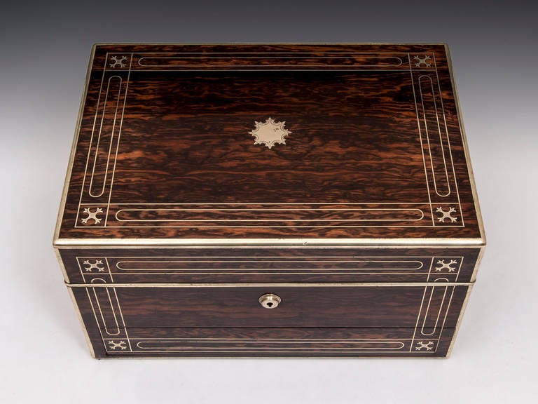 Brass bound Jewelry Box by Austin of Dublin, veneered in exquisite Coromandel with fine inlaid and engraved brass stringing typical of the Austin work shop. 

The interior when opened locks into position with a sprung brass square catch which can