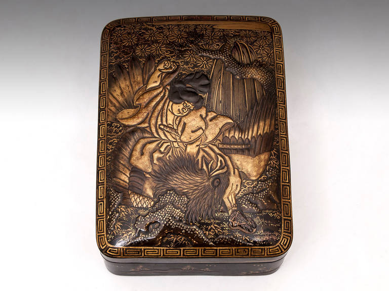 A Japanese tortoiseshell box highly decorated with takamaki-e and hiramaki-e lacquer, depicting a samurai fighting a mythical bird on the lid, and typical Japanese landscapes to the sides. The interior is also decorated with gold flowers.