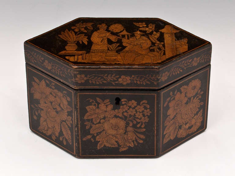 Elongated hexagonal Penwork Tea Caddy with chinoiserie and floral scenes. 

The interior is lined with a salmon coloured paper. 

This Tea caddy comes with a fully working lock and tasselled key.