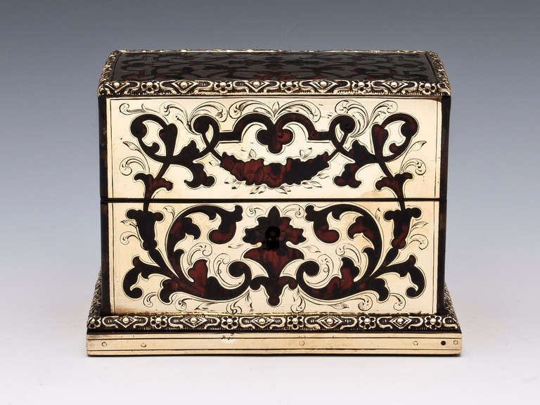 Perfume Box predominantly brass with inlaid tortoiseshell otherwise known as Boulle. 

The interior is lined with pink velvet and includes three bottles with gilded floral reliefs. 

There is minor damage to one of the perfume bottle stoppers