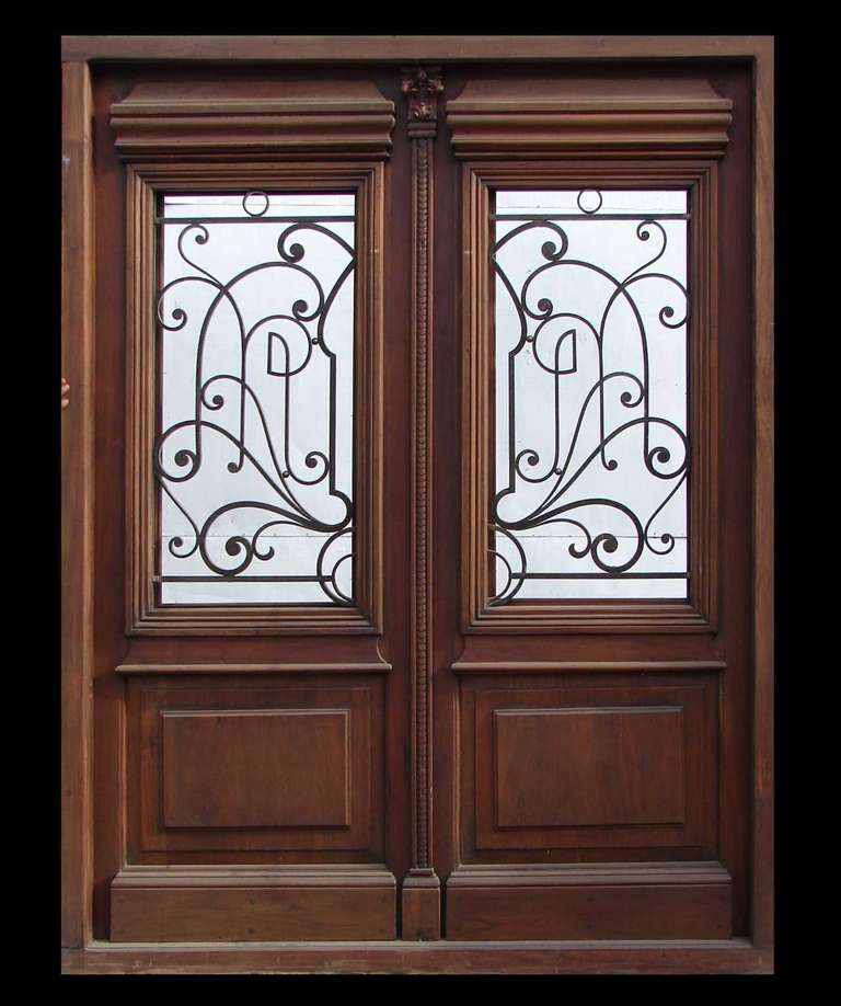 Pre-hung entrance door with stunning wrought iron inserts. It,s made in solid mahogany wood. It has raised panels at the bottom and high relief carvings made by hand at the top. It,s fully restored and pre-finished. Ready to install. #1957