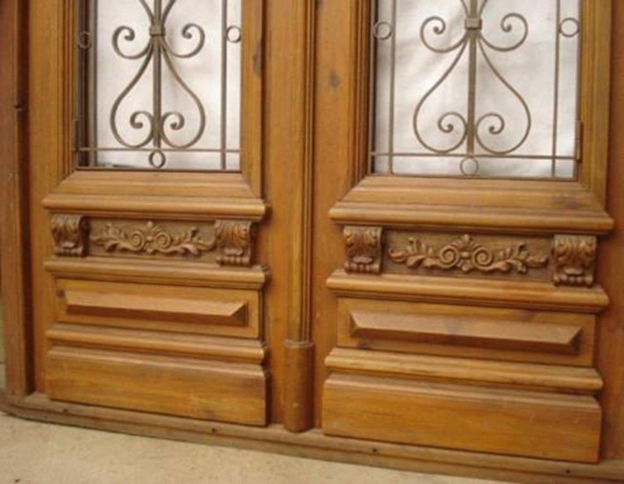 Italian double entry door with wrought iron inserts and European heart pine wood. All moldings and woodwork are hand carved, the iron hinges are hand forged and each door has a speak easy window. This door is pre-hung and ready to install.