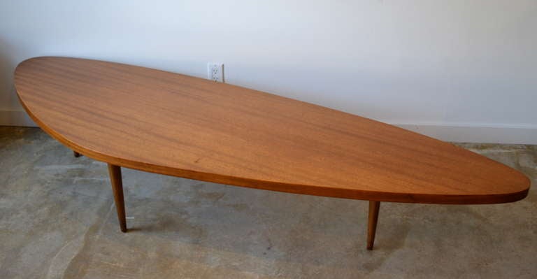 striped mahogany boomerang coffee table by harvey probber, massive top supported by tapered legs.
