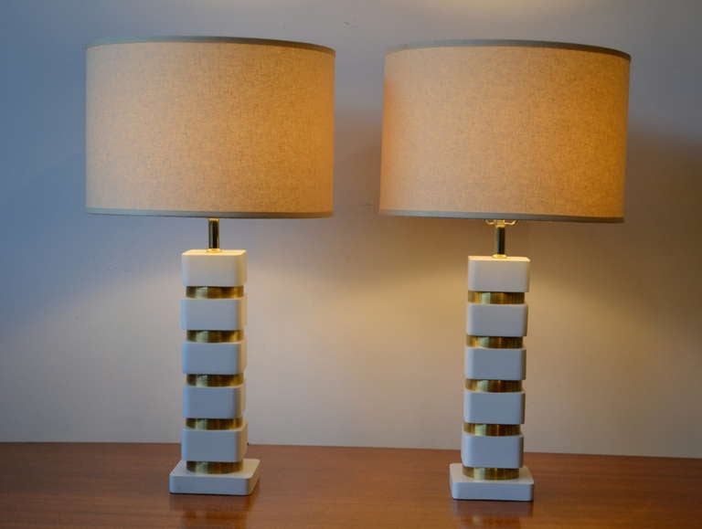 Stunningly modern for their time, 1940s, expertly restored brass rings and matte white wood table lamps. These lamps are elegant with a soft patina.